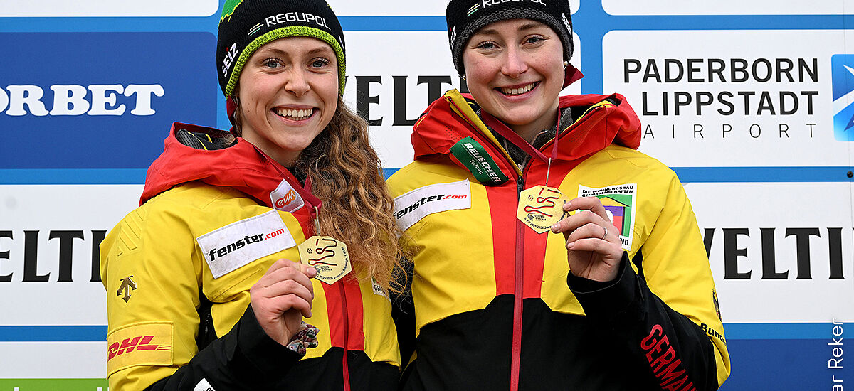 Charlotte Candrix and Lena Brunnhübner as winners in the two-man bobsleigh with gold medals and REGUPOL hats