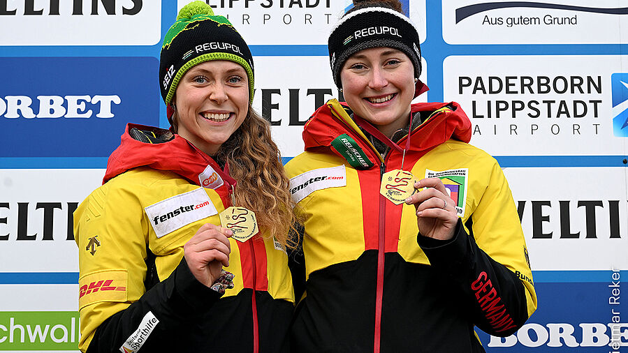Charlotte Candrix and Lena Brunnhübner as winners in the two-man bobsleigh with gold medals and REGUPOL hats